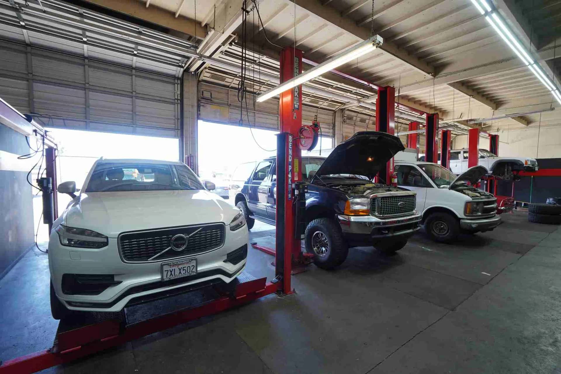 Vehicles on lifts inside the Route 66 Auto Repair service bays