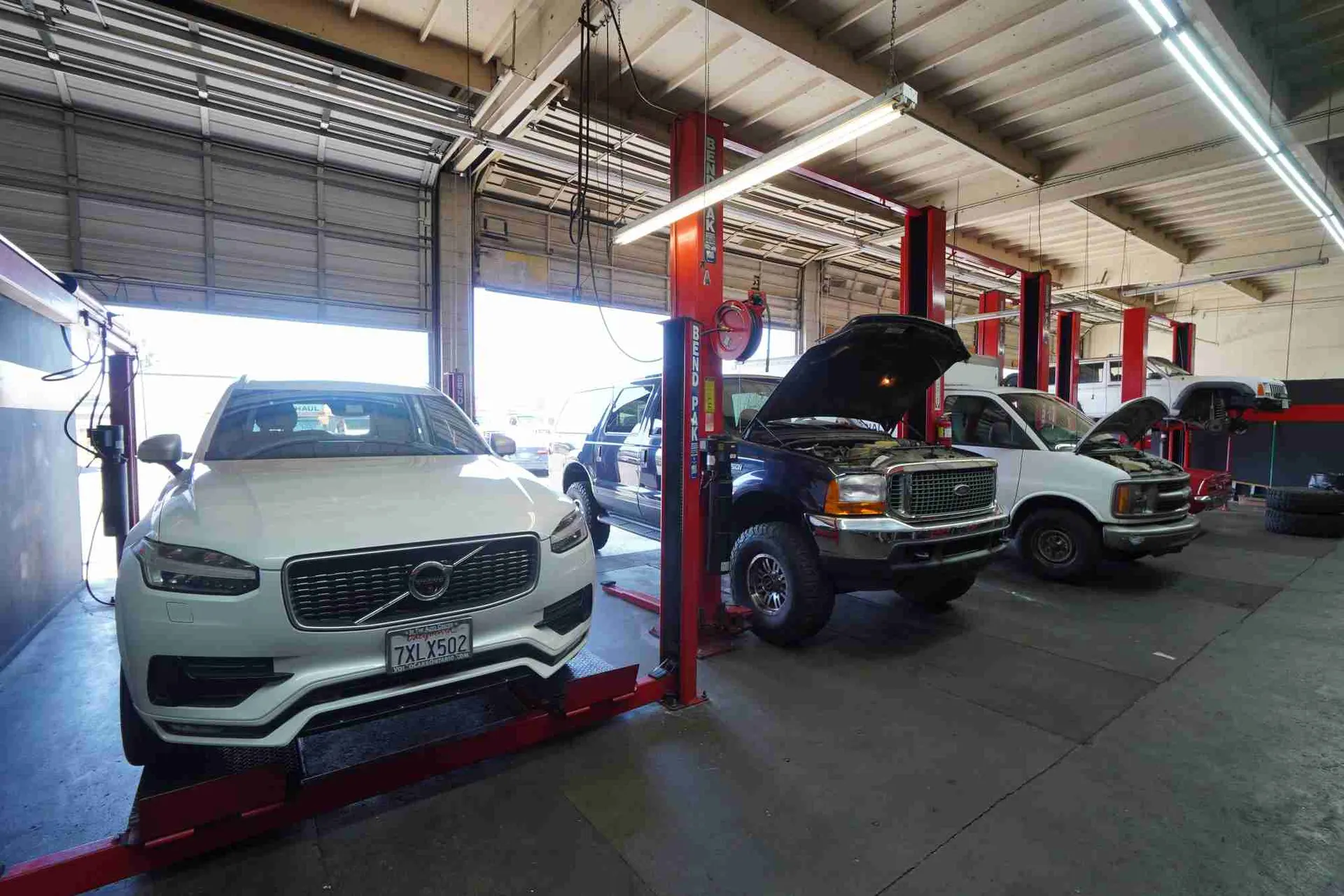 Vehicles on lifts inside the Route 66 Auto Repair service bays