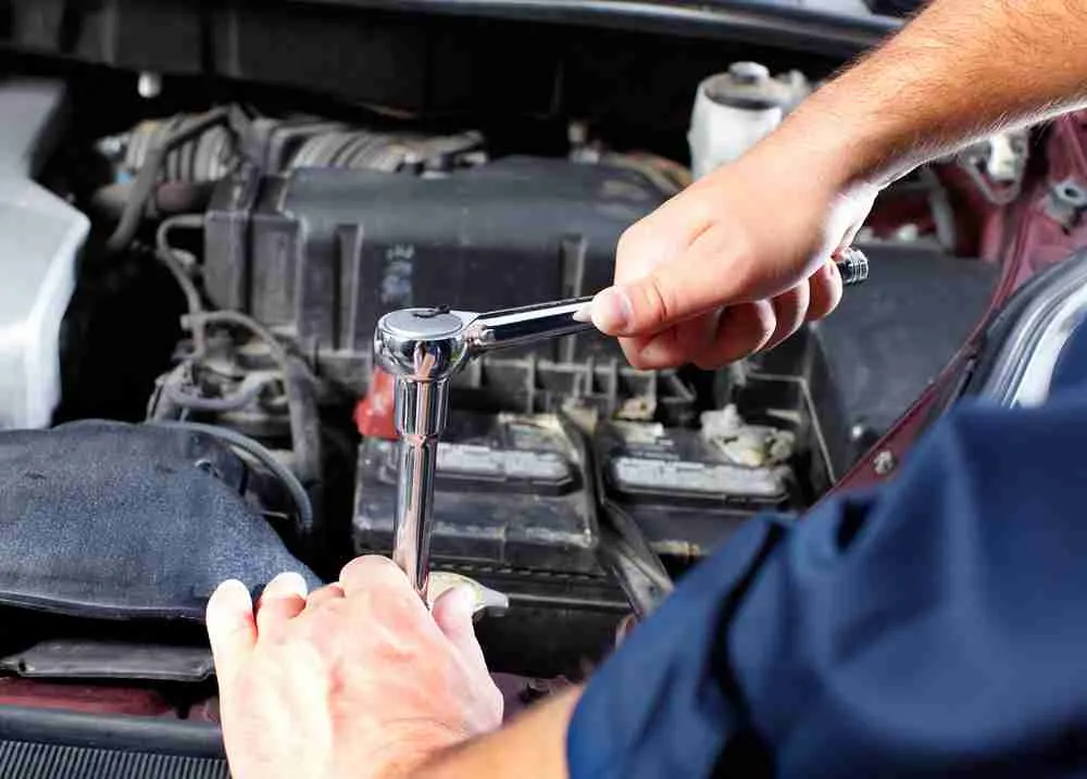 Technician working on an alternator in an engine bay