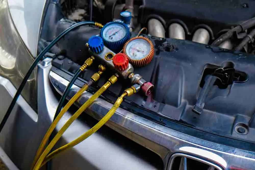 AC gauges connected to a vehicle's air conditioning ports