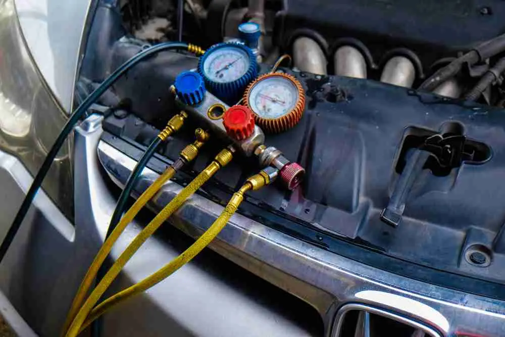 AC gauges connected to a vehicle's air conditioning ports