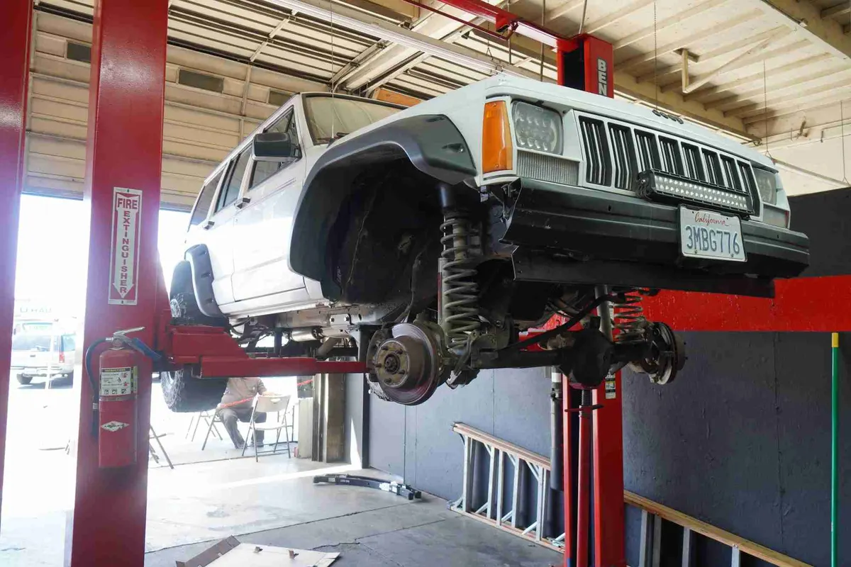 SUV raised on a lift with wheels off for brake and suspension work
