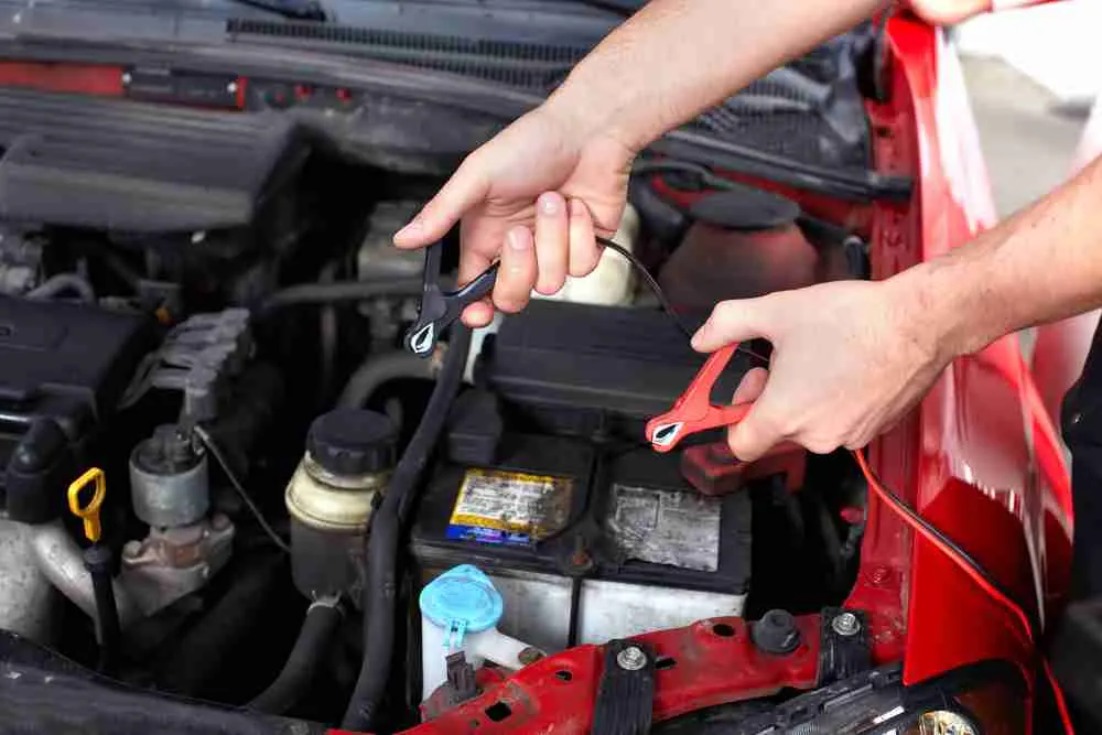 Technician testing a car battery with clamps