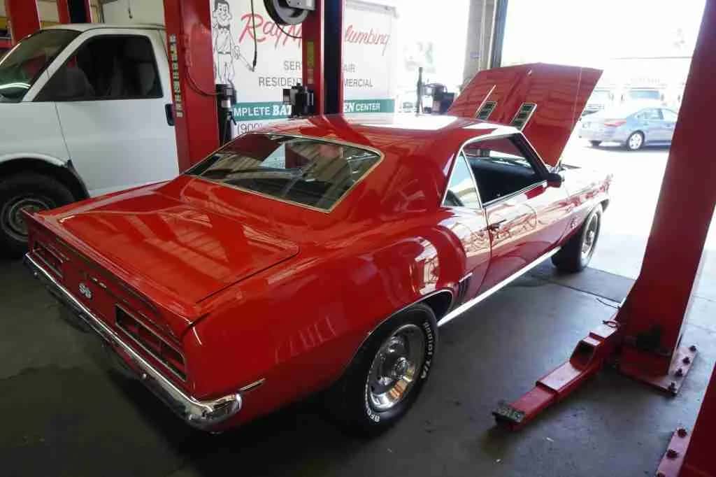 Red classic muscle car raised on a lift