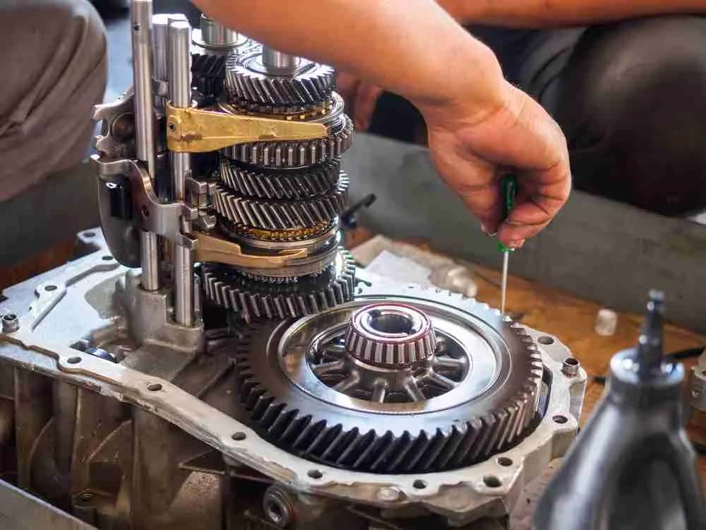 Technician working on an open transmission gear set