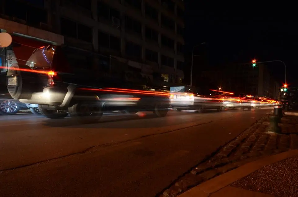 Street at night with car lights and traffic signals