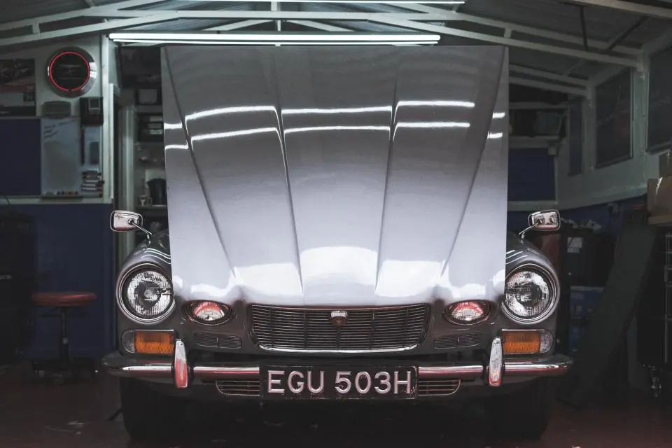 Front of a classic car with round headlights in a garage