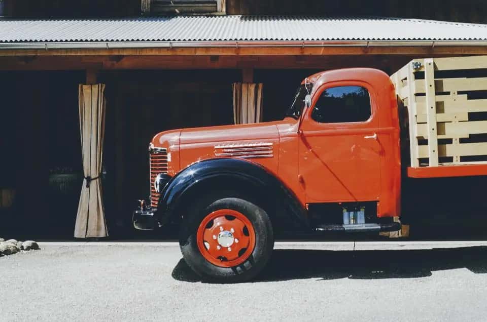 Vintage orange work truck parked on a street