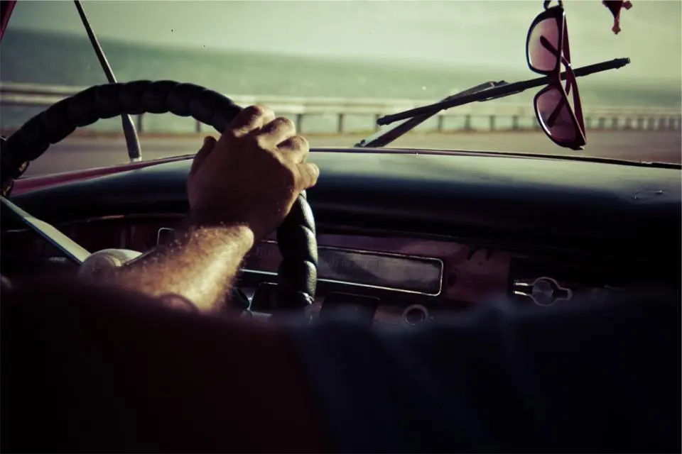 Driver's hand on a steering wheel