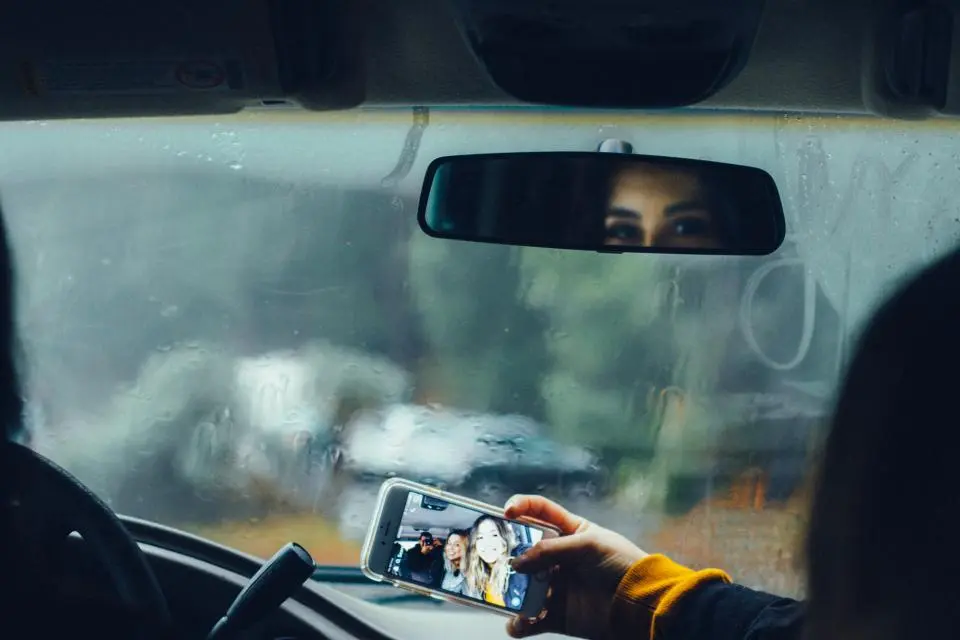 Passenger taking a photo from inside a car
