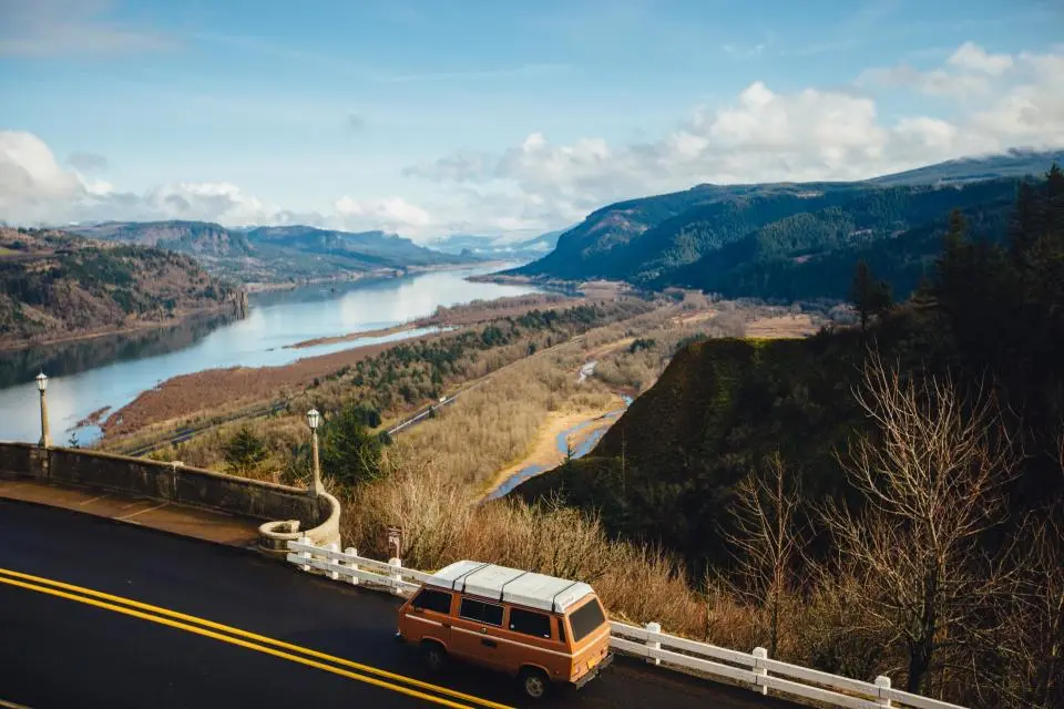 Van driving on a highway through green hills